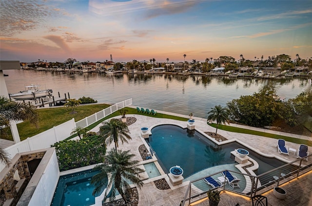 pool at dusk featuring a water view