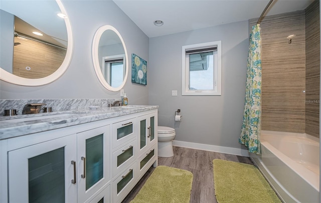 full bathroom featuring hardwood / wood-style flooring, vanity, toilet, and shower / bath combo