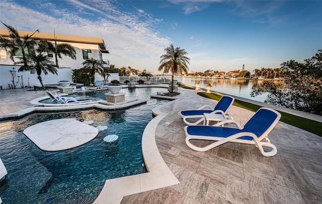 view of pool featuring a jacuzzi, a patio area, and a water view