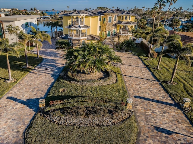 view of home's community featuring a lawn and a water view