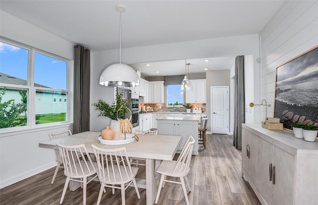 dining room with sink, a wealth of natural light, and dark wood-type flooring