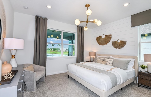 carpeted bedroom featuring an inviting chandelier and wood walls