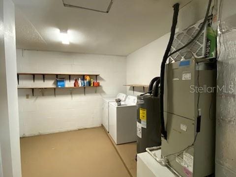 clothes washing area with washing machine and dryer and water heater