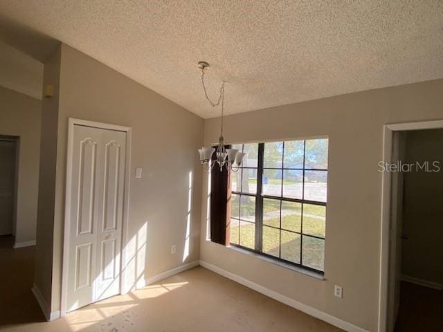 unfurnished dining area featuring vaulted ceiling, a chandelier, and a textured ceiling