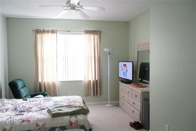 carpeted bedroom featuring multiple windows, a textured ceiling, and ceiling fan