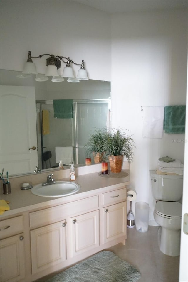 bathroom with vanity, an enclosed shower, tile patterned flooring, and toilet