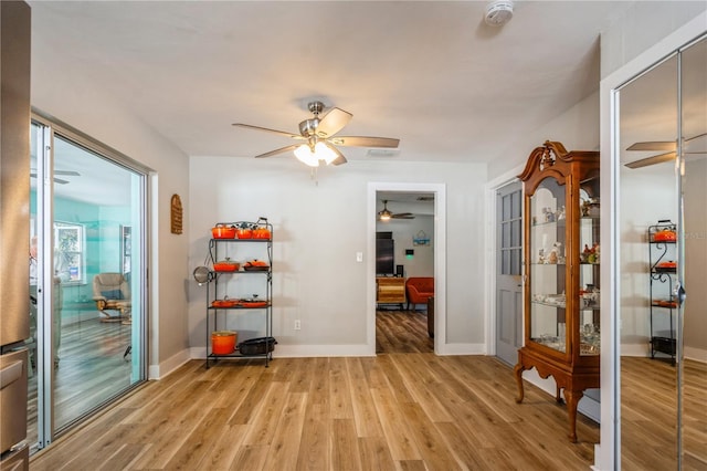 workout area featuring light hardwood / wood-style flooring and ceiling fan