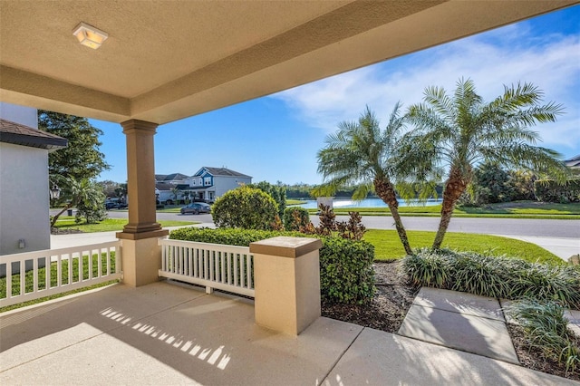 view of patio featuring a porch and a water view