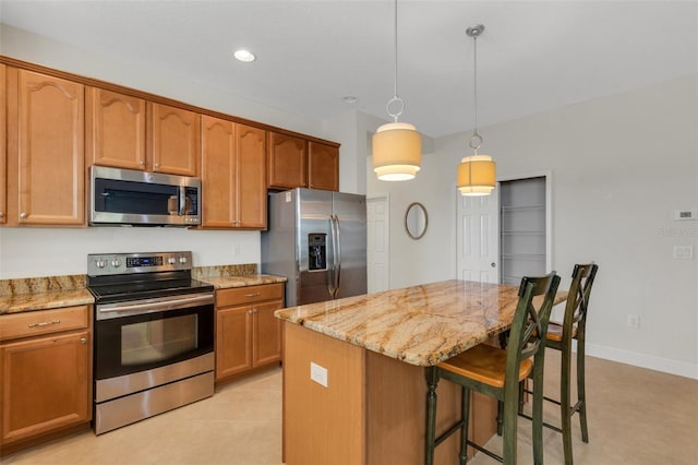 kitchen featuring a breakfast bar, light stone countertops, stainless steel appliances, and a center island