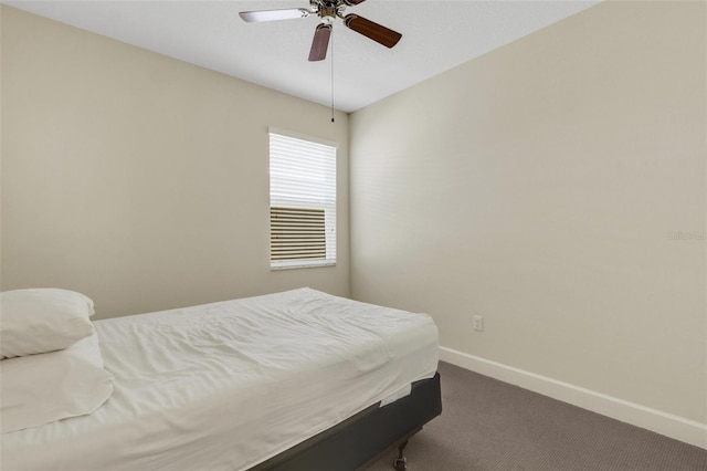 bedroom featuring dark carpet, a ceiling fan, and baseboards