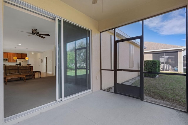 unfurnished sunroom with ceiling fan and a wealth of natural light