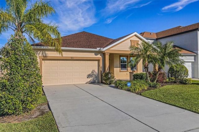 single story home with driveway, an attached garage, and stucco siding