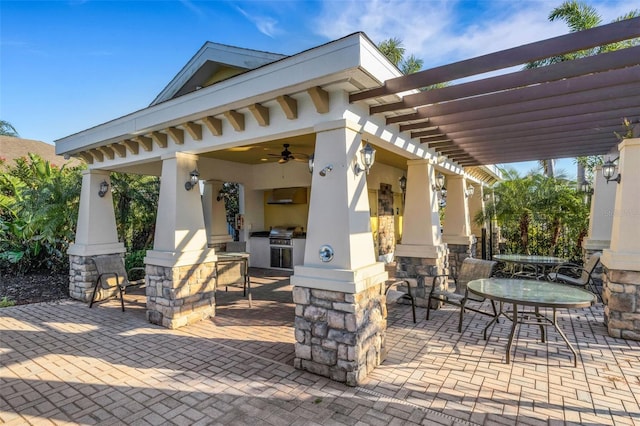 view of patio with ceiling fan, outdoor dining area, an outdoor kitchen, and a pergola