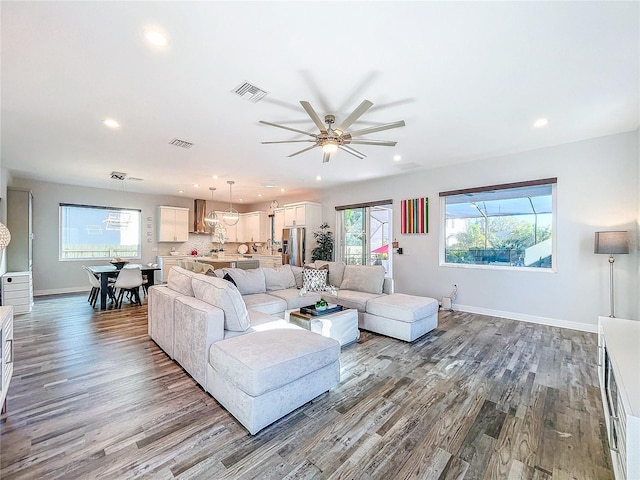 living room featuring wood-type flooring and ceiling fan