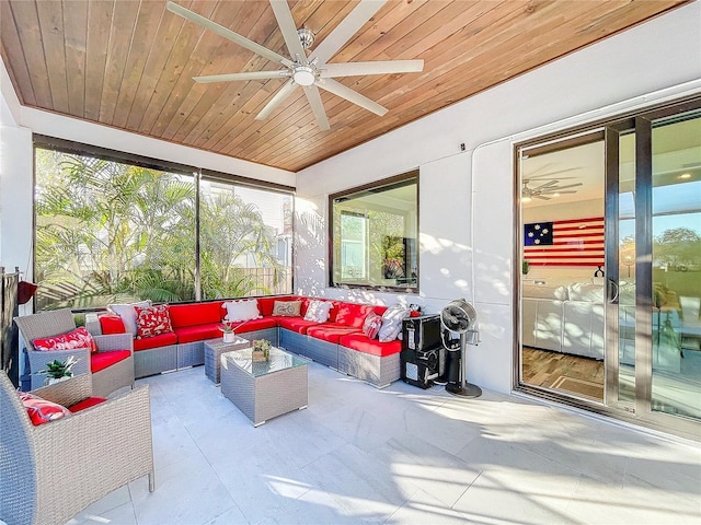 sunroom / solarium with lofted ceiling, wood ceiling, and a ceiling fan