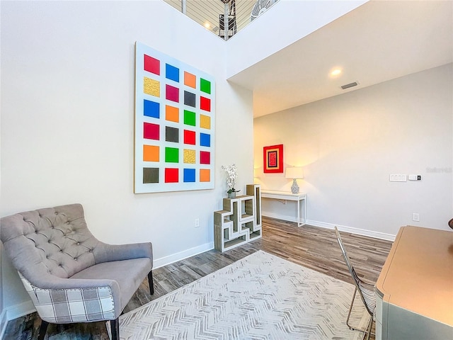 sitting room with visible vents, baseboards, and wood finished floors