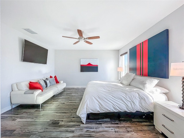 bedroom with a ceiling fan, wood finished floors, visible vents, and baseboards