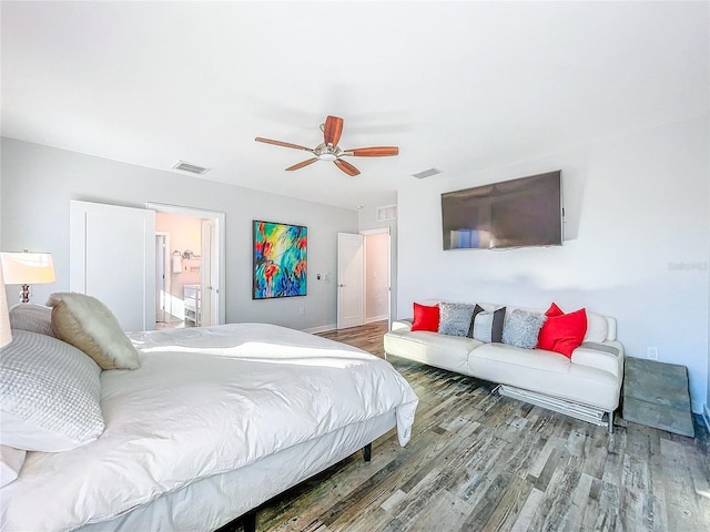 bedroom with ceiling fan, visible vents, and wood finished floors