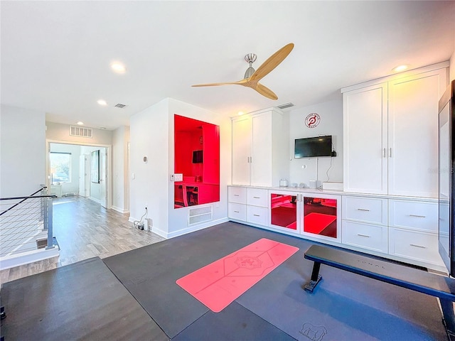 exercise area with ceiling fan and dark hardwood / wood-style floors