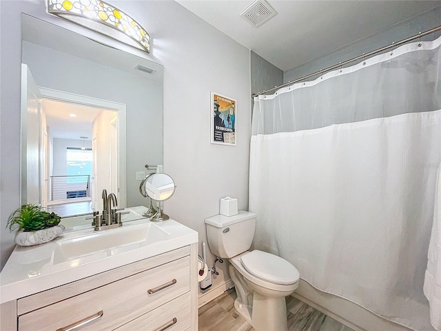 full bath with visible vents, toilet, vanity, and wood finished floors