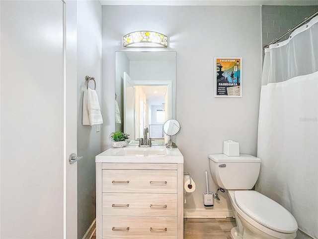 bathroom with walk in shower, vanity, and toilet