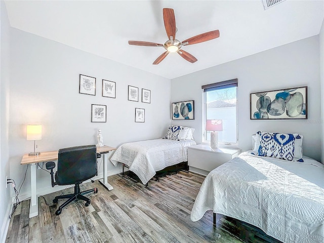 bedroom with baseboards, wood finished floors, and a ceiling fan