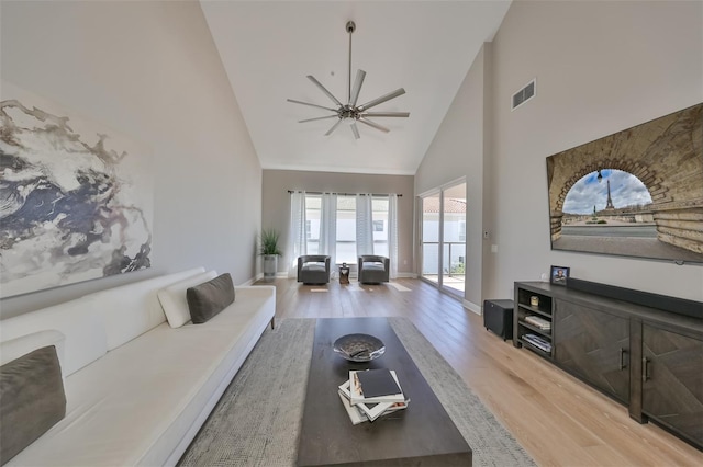 living room featuring wood-type flooring, high vaulted ceiling, and ceiling fan