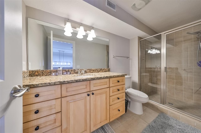 bathroom with vanity, toilet, a shower with shower door, and tile patterned flooring