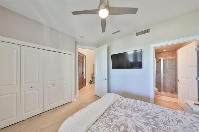 bedroom with ceiling fan, light wood-type flooring, ensuite bath, and a closet