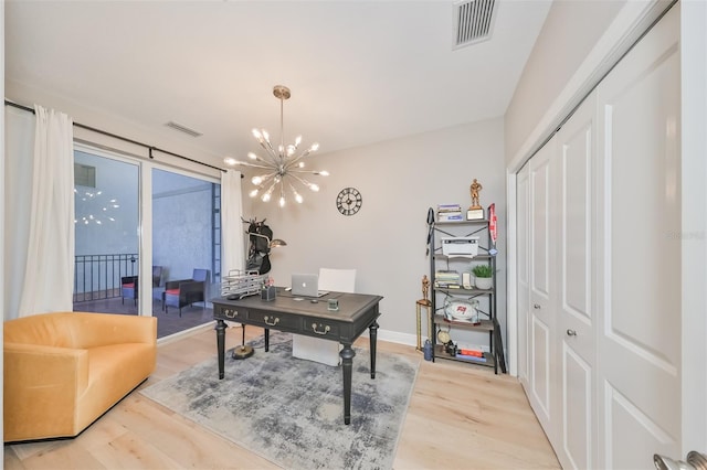 office area with an inviting chandelier and light hardwood / wood-style flooring