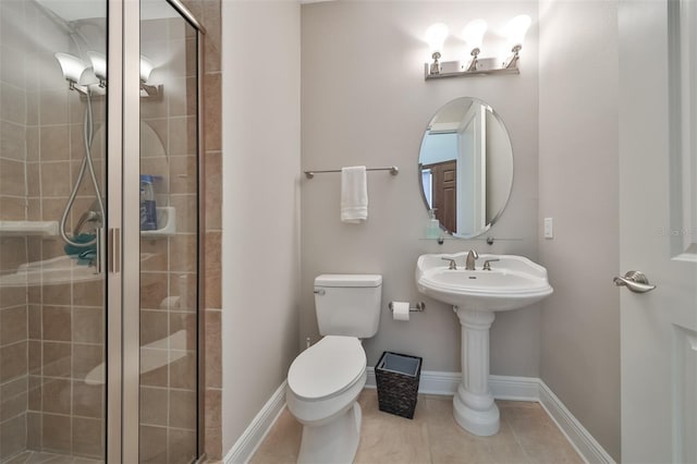 bathroom with tile patterned flooring, a shower with shower door, and toilet