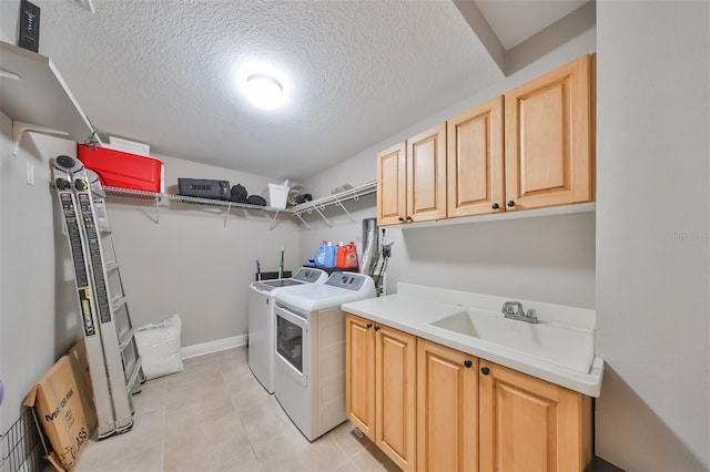 laundry area featuring sink, cabinets, separate washer and dryer, a textured ceiling, and light tile patterned floors