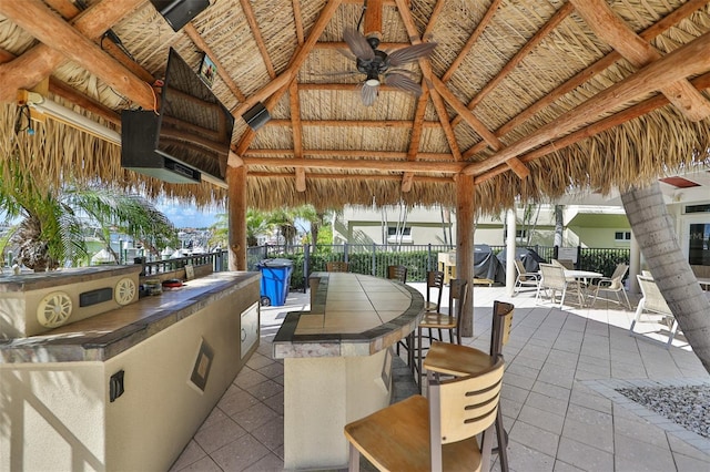 view of patio with a gazebo, ceiling fan, and a bar