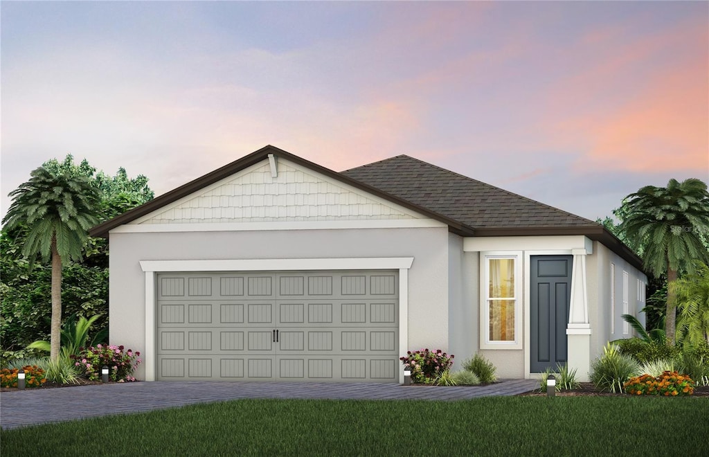 ranch-style house featuring a garage and a lawn