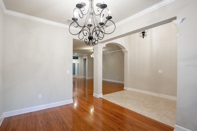 unfurnished dining area featuring crown molding, light hardwood / wood-style floors, and decorative columns