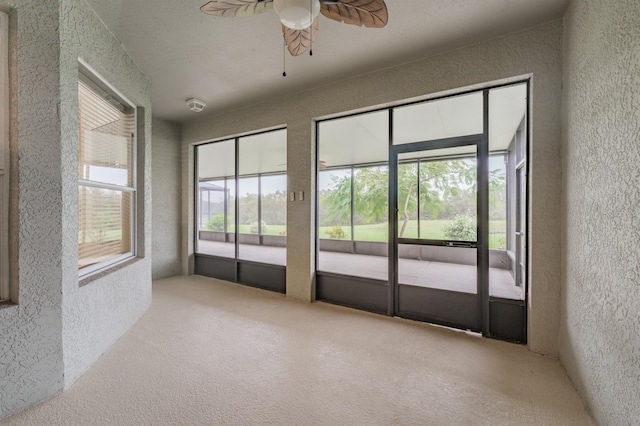 carpeted spare room with ceiling fan and a healthy amount of sunlight