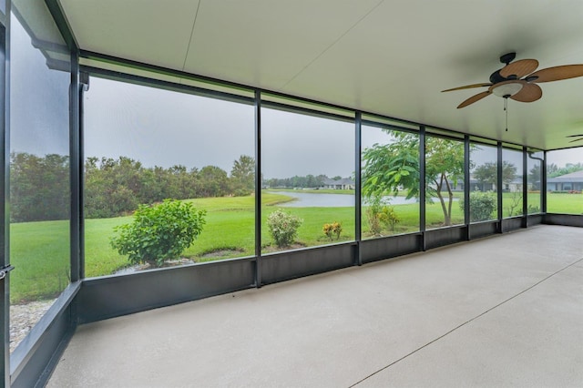 unfurnished sunroom with ceiling fan and a water view