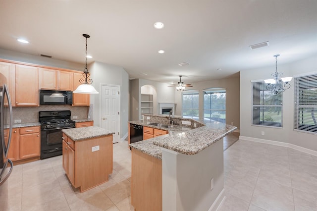 kitchen featuring decorative light fixtures, tasteful backsplash, a center island, and black appliances