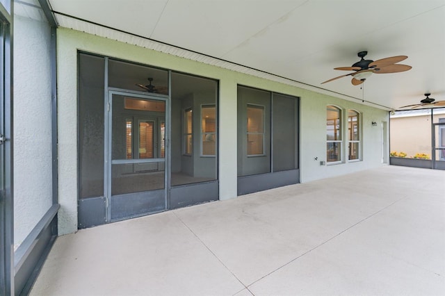 unfurnished sunroom with ceiling fan