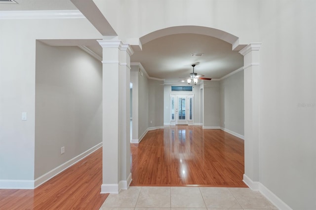 unfurnished living room with light tile patterned flooring, ornamental molding, and decorative columns