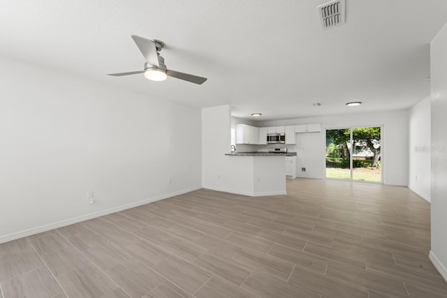 unfurnished living room with ceiling fan