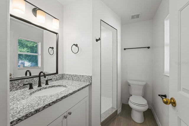 bathroom with a shower, vanity, and toilet