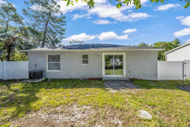 back of house with central AC and a yard