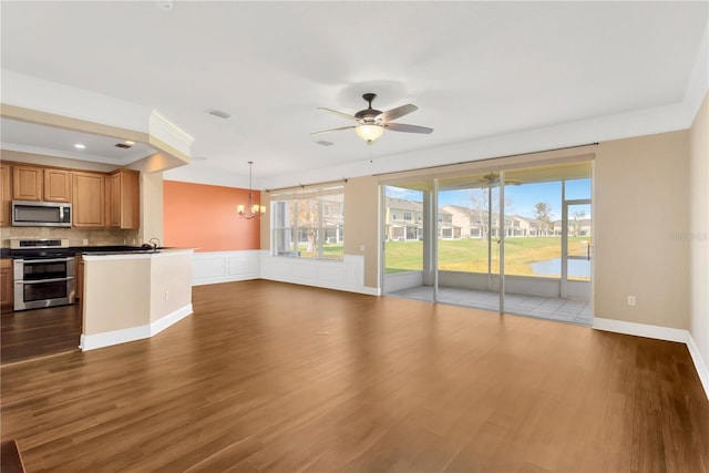 unfurnished living room with crown molding, sink, dark hardwood / wood-style floors, and ceiling fan with notable chandelier