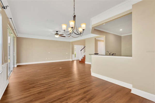 interior space featuring ornamental molding, ceiling fan with notable chandelier, and dark hardwood / wood-style flooring