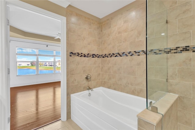 bathroom featuring a water view, ceiling fan, tile patterned floors, and a washtub