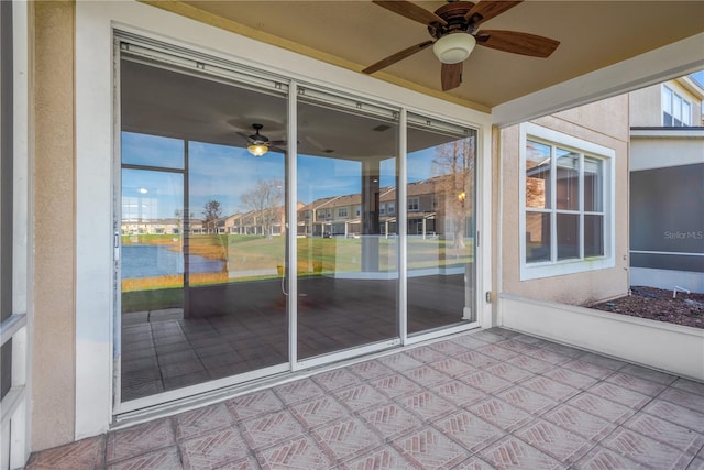 unfurnished sunroom with ceiling fan