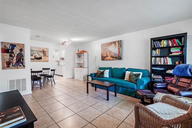 tiled living room featuring a textured ceiling