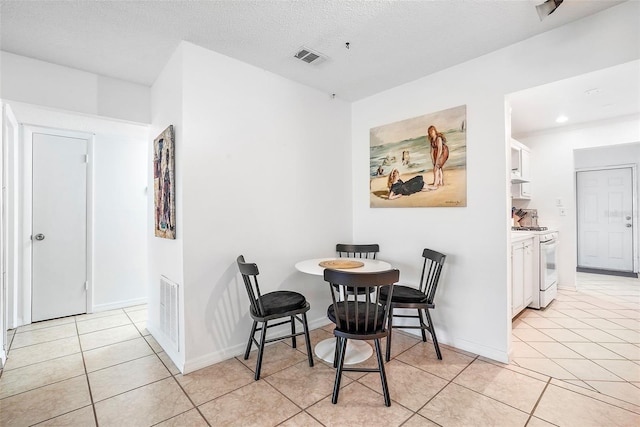 tiled dining room with a textured ceiling