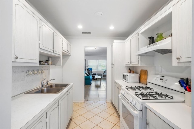 kitchen with white cabinetry, sink, light tile patterned floors, crown molding, and white appliances